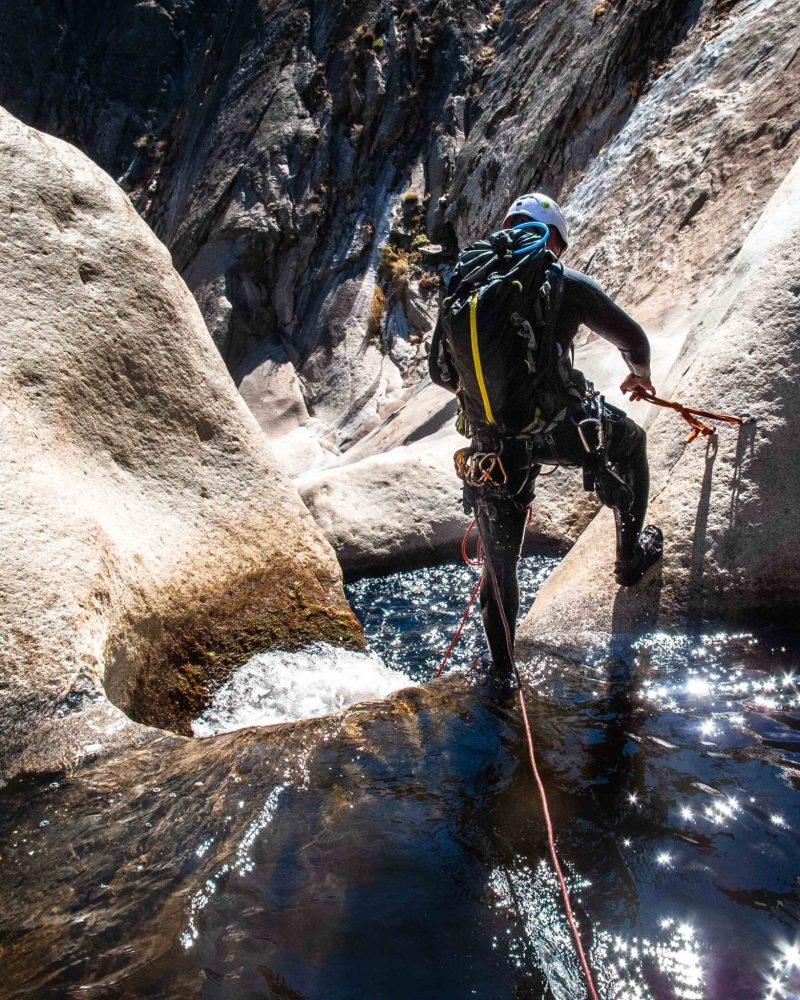 Canyoneer Sets Anchor Above Granite Waterfall