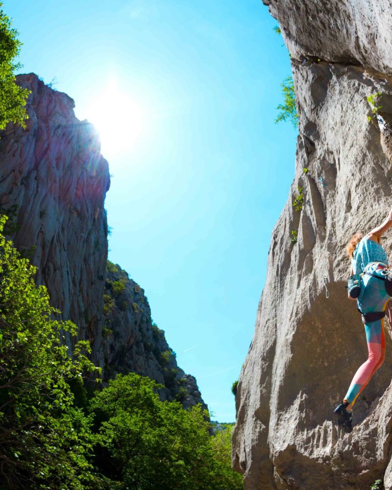Rock climbing and mountaineering in the Paklenica National Park. A woman overcomes a challenging climbing route on natural terrain. Climber trains on the rocks of Croatia.