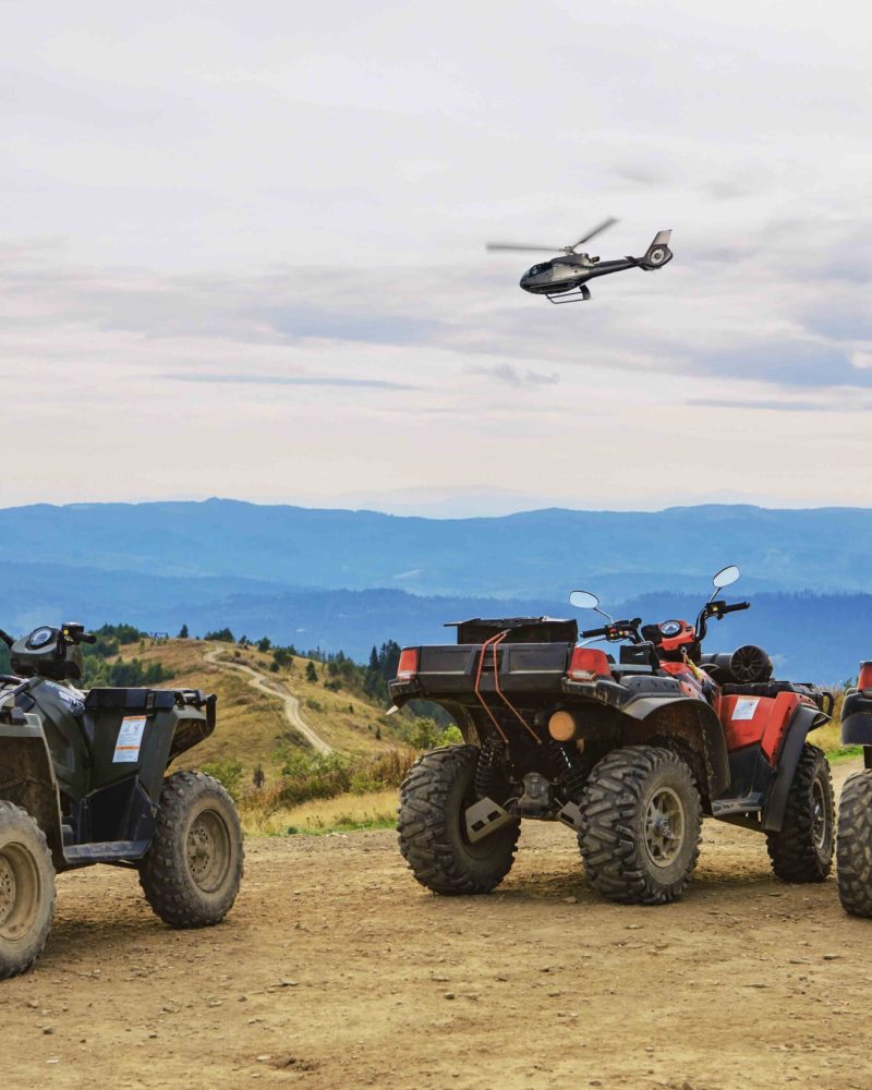 people riding on all terrain vehicle by mountains autumn summer time