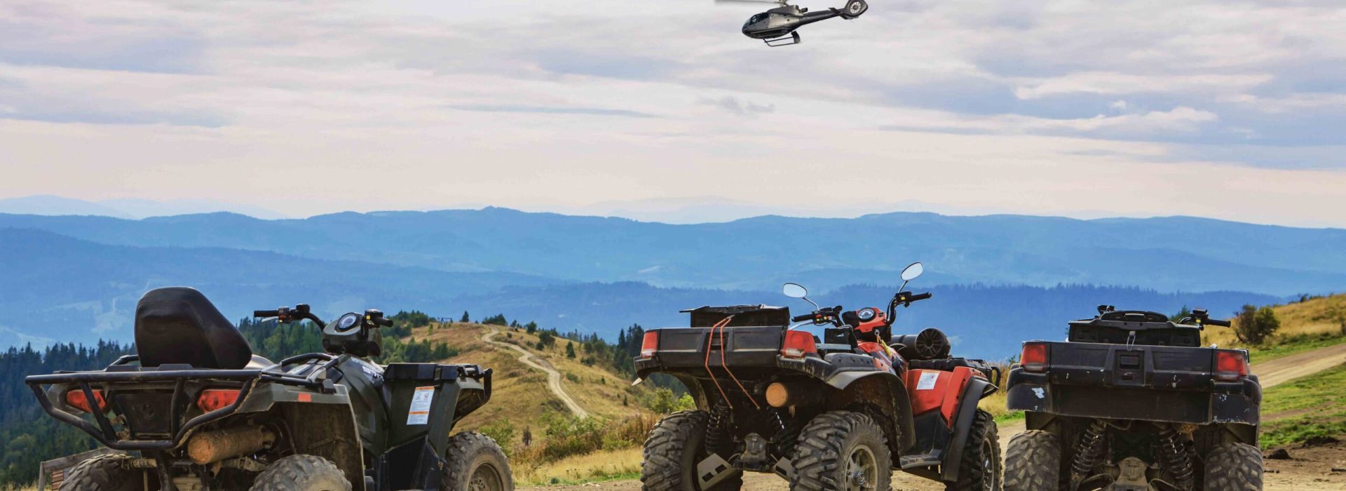 people riding on all terrain vehicle by mountains autumn summer time