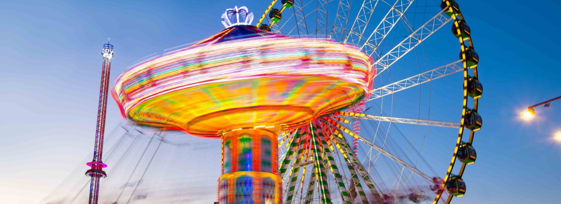Funfair panorama wiht ferris wheel and carousels on big german f