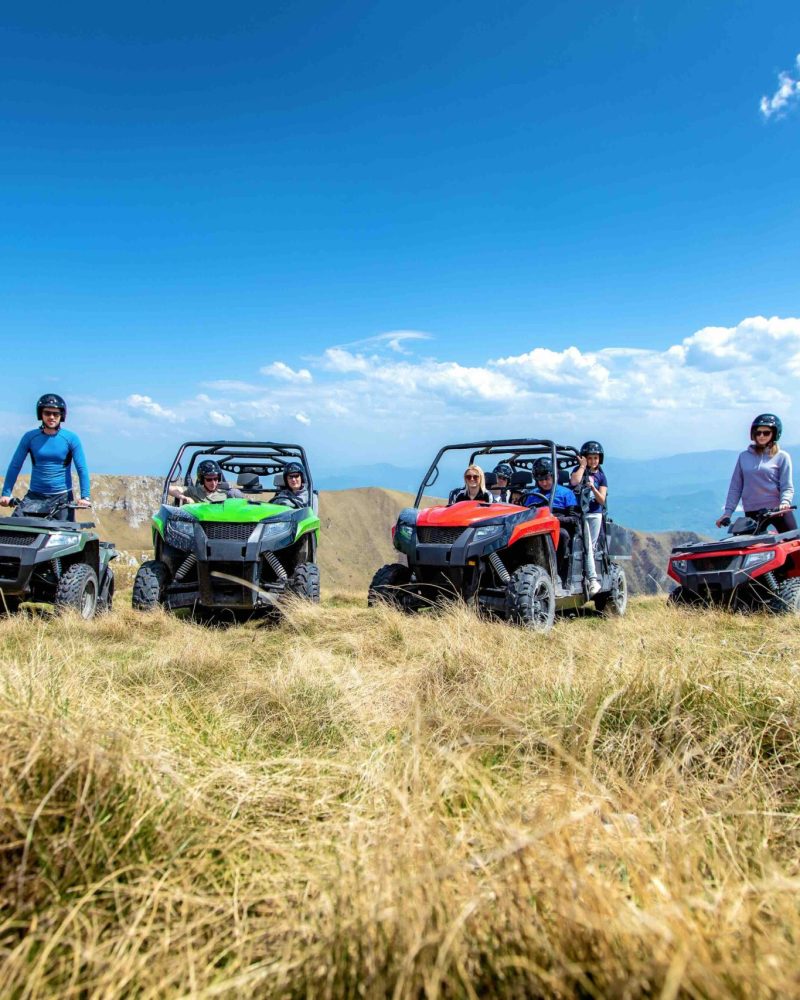 Friends driving off-road with quad bike or ATV and UTV vehicles.