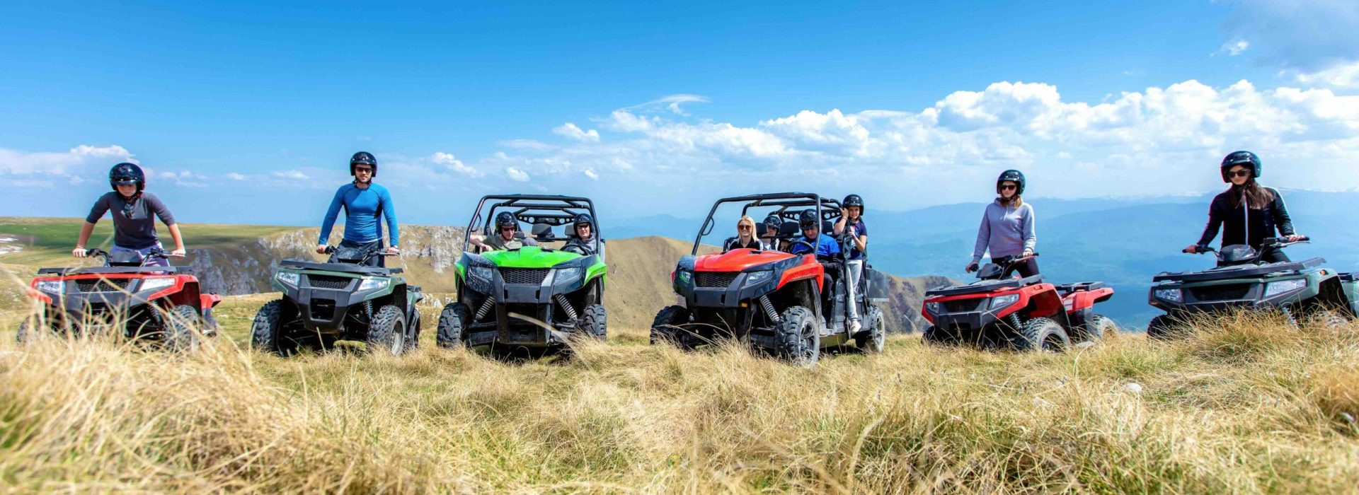 Friends driving off-road with quad bike or ATV and UTV vehicles.