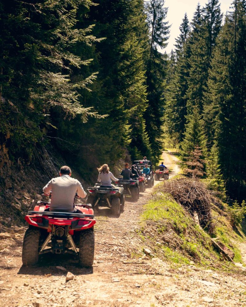 A tour group travels on ATVs and UTVs on the mountains