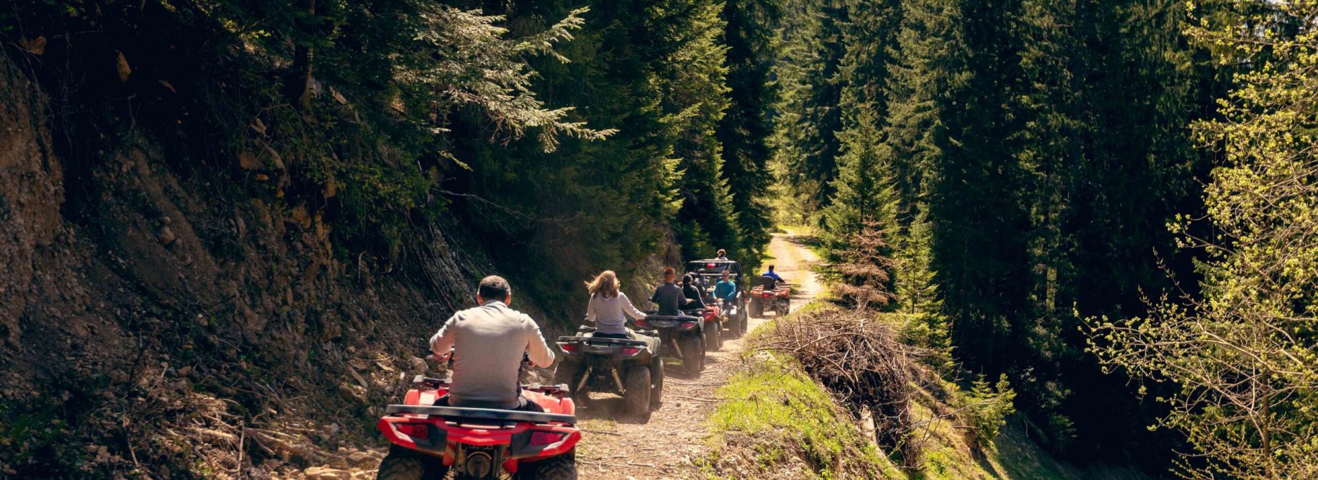 A tour group travels on ATVs and UTVs on the mountains