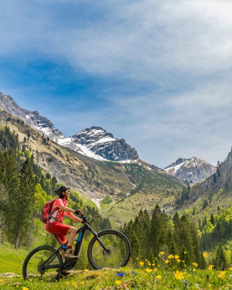 pretty senior woman riding her electric mountain bike the Oy Tal Valley near Oberstdorf, Allgau Alps, Bavaria, Germany
