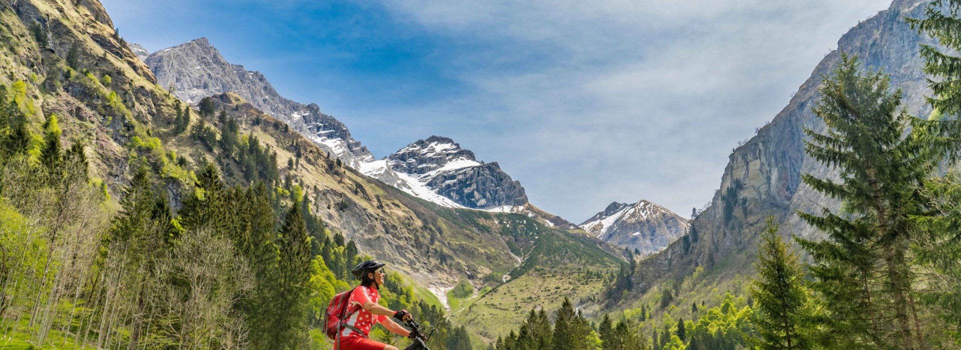 pretty senior woman riding her electric mountain bike the Oy Tal Valley near Oberstdorf, Allgau Alps, Bavaria, Germany