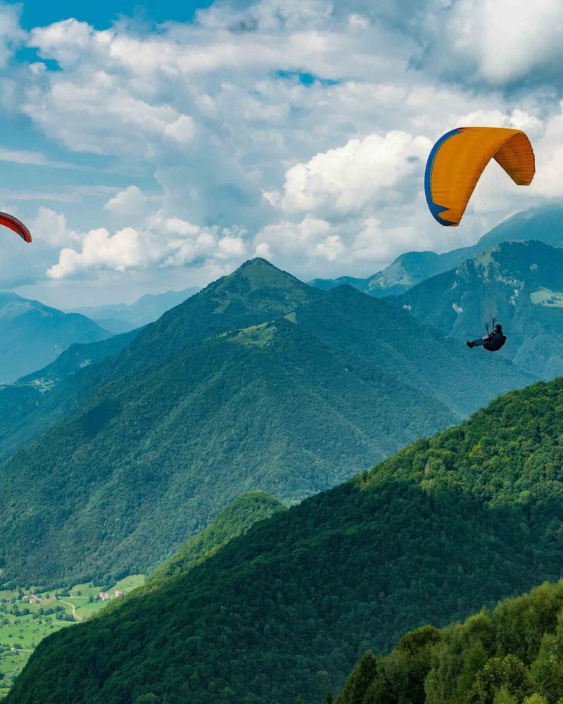 Colorful paraglider wings fly in the mountains near Tolmin, Slovenia. Soca valley, the Europe popular tourist destination, Mecca for extreme sports and active lifestyle.